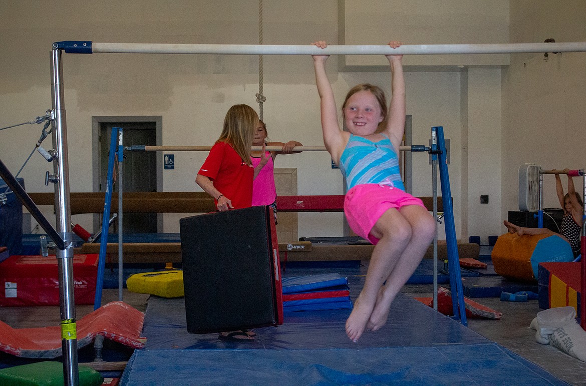 A young gymnast practices on the bars at AIM Gymnastic Center during recreation gymnastics practice Wednesday afternoon.