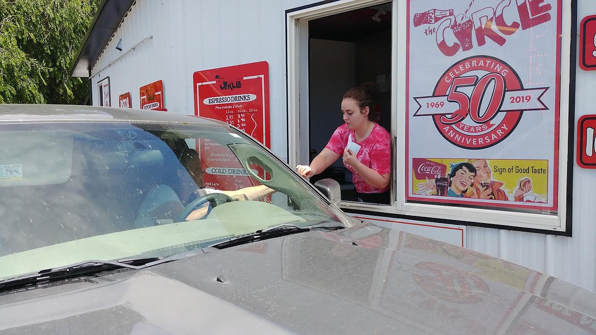 Grace Gamboa hands a customer change at the drive through window at The Circle restaurant. (Chuck Bandel/Valley Press)