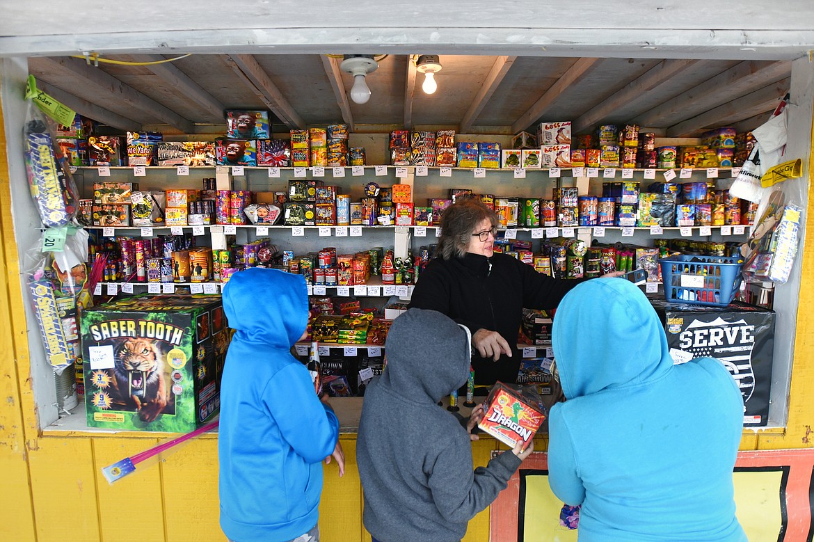 Customers purchase fireworks from Dorothy Robinson at Robinson’s Fireworks in Evergreen on Tuesday, June 30. (Casey Kreider/Daily Inter Lake)