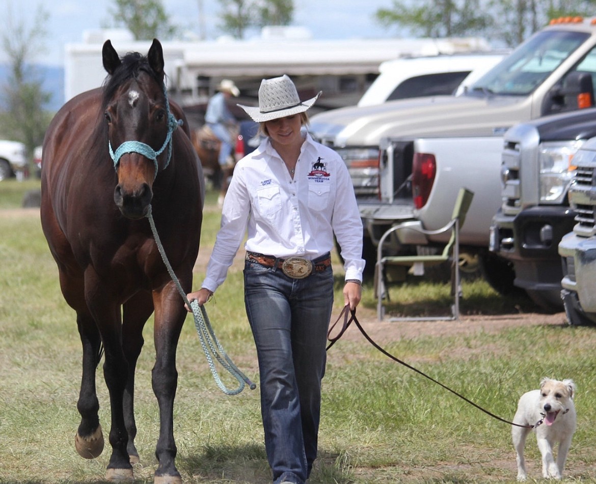 Aubree Skone and her barrel racing horse, Six, make their way through the parking lot at a rodeo in Coulee City.