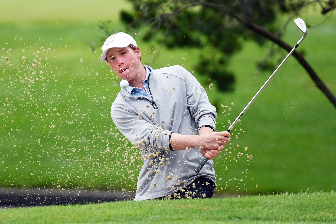 Cameron Kahle chips out of a sand trap on the 18th hole of the North Course during the Earl Hunt 4th of July Tournament at Whitefish Lake Golf Club on Thursday. (Casey Kreider/Daily Inter Lake)