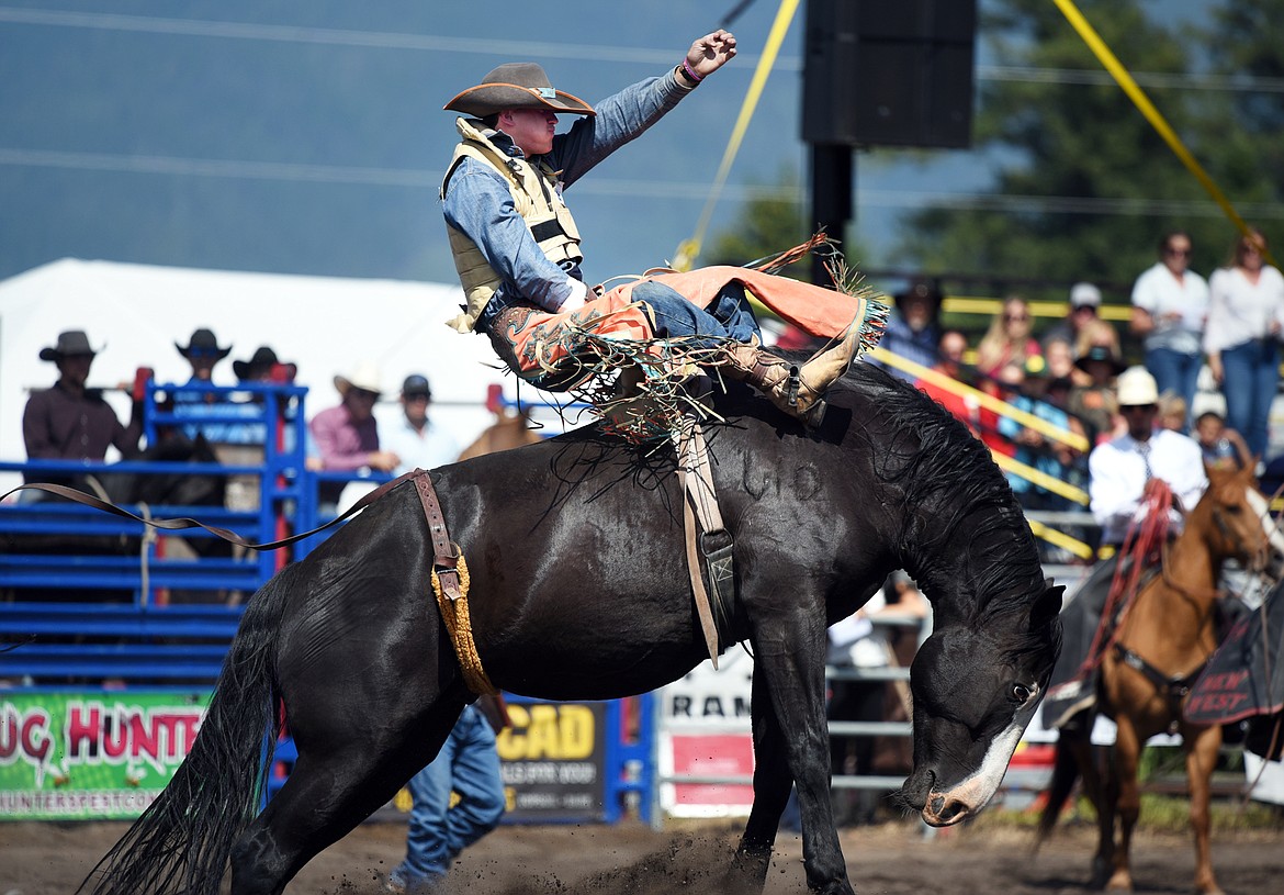 Tanner Wyatt Phillips, of Brooklyn, Michigan, holds on to his horse 3 Seconds Out during bareback riding at the Bigfork Rodeo on Saturday, July 4. (Casey Kreider/Daily Inter Lake)