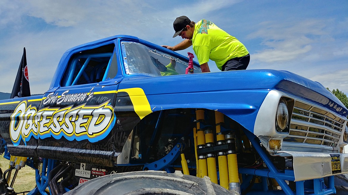 Monster truck driver Eric Swanson cleans the windshield of “Obsessed.” (Chuck Bandel/Valley Press)