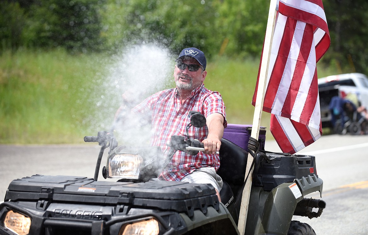 A parade participant sprays the crowd with water.