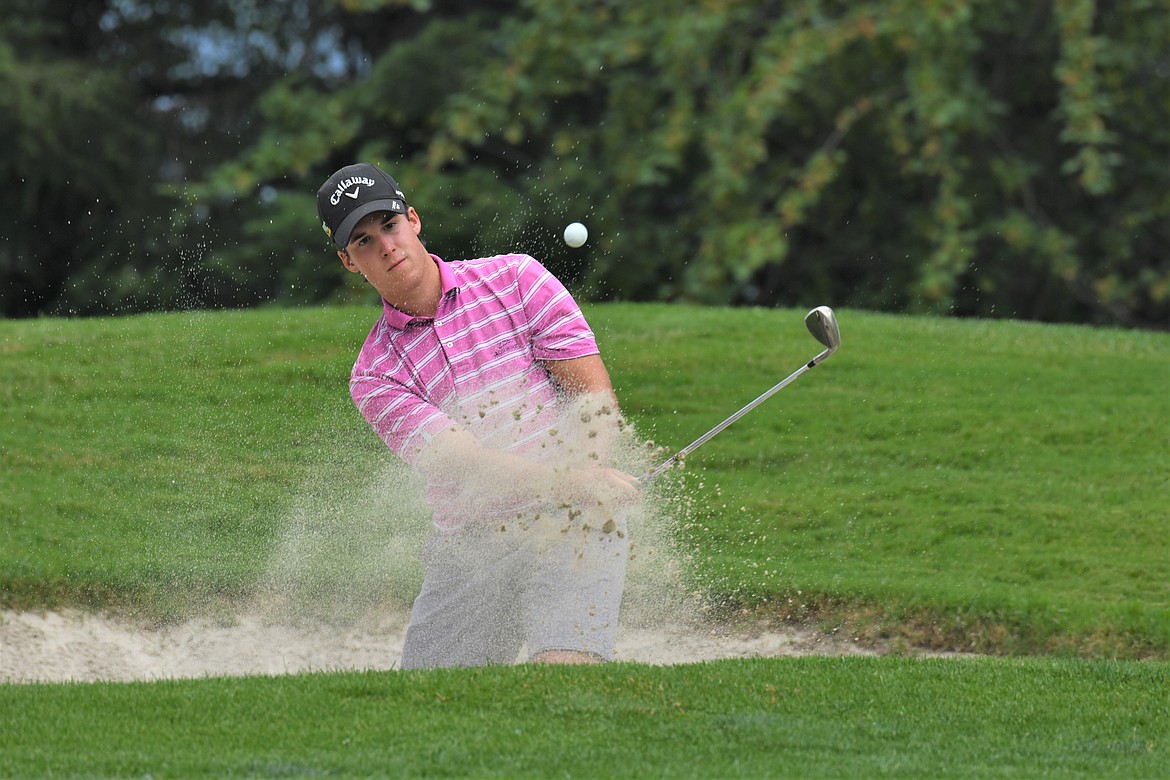 Joe Stover chips a shot out of the bunker during Whitefish Lake Golf Course’s Fourth of July tournament. (Jeff Doorn photo)