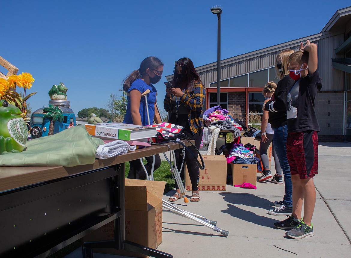 Kids and staff from Boys & Girls Clubs of the Columbia Basin take a break outside at the Summer Yard Sale on Friday afternoon in Moses Lake.