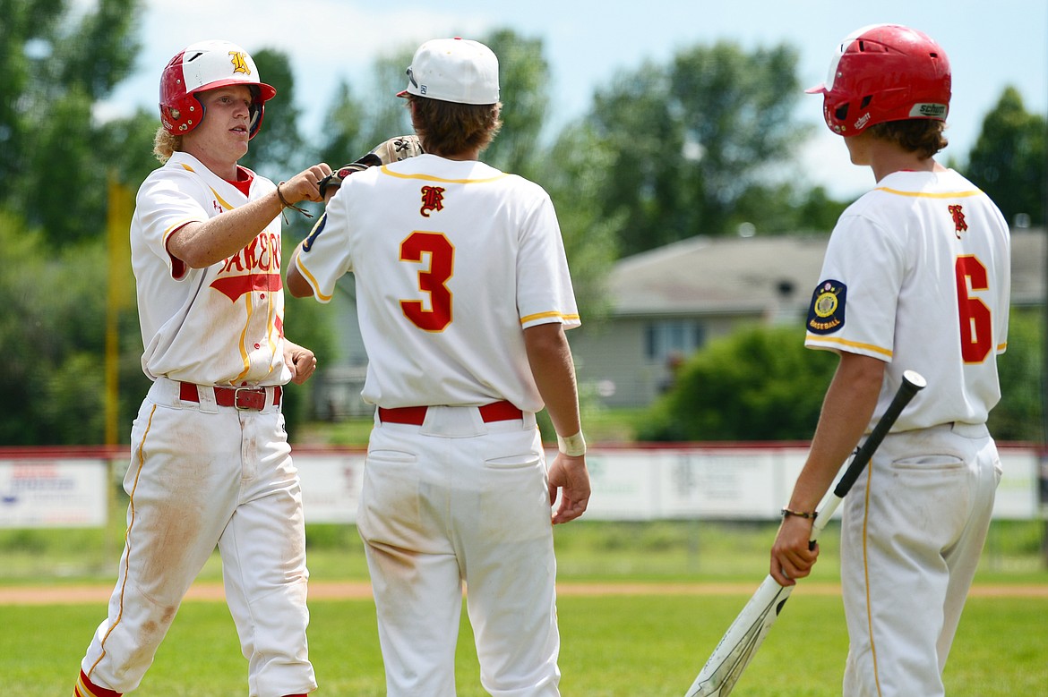 Kalispell Lakers AA’s Connor Drish, left, is congratulated by Gage Brink and Joe Schlegel after scoring on a bases loaded walk in the bottom of the fifth inning against Belgrade at Griffin Field on Thursday, July 16. (Casey Kreider/Daily Inter Lake)