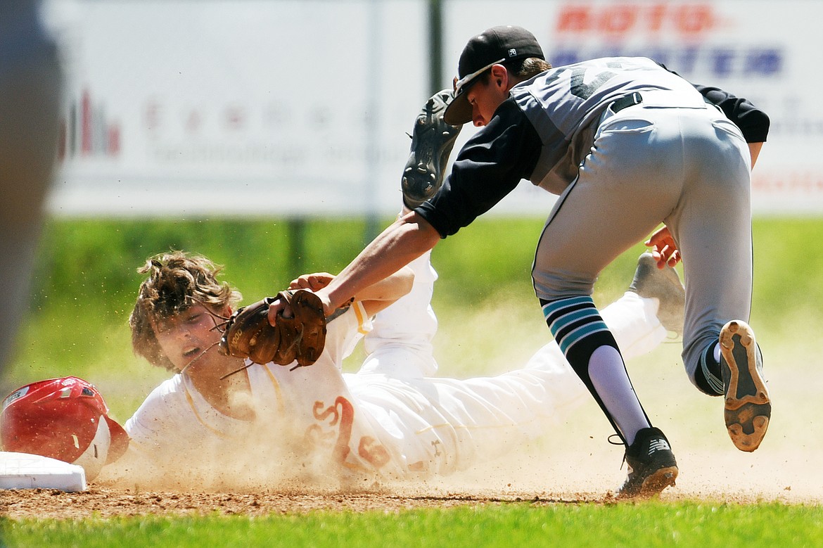 Kalispell’s Joe Schlegel is tug out at third base by Belgrade third baseman Aidan Kulbeck after trying to get to third from first base on a sacrifice bunt by Ben Corriveau in the bottom of the third inning at Griffin Field on Thursday, July 16. (Casey Kreider/Daily Inter Lake)