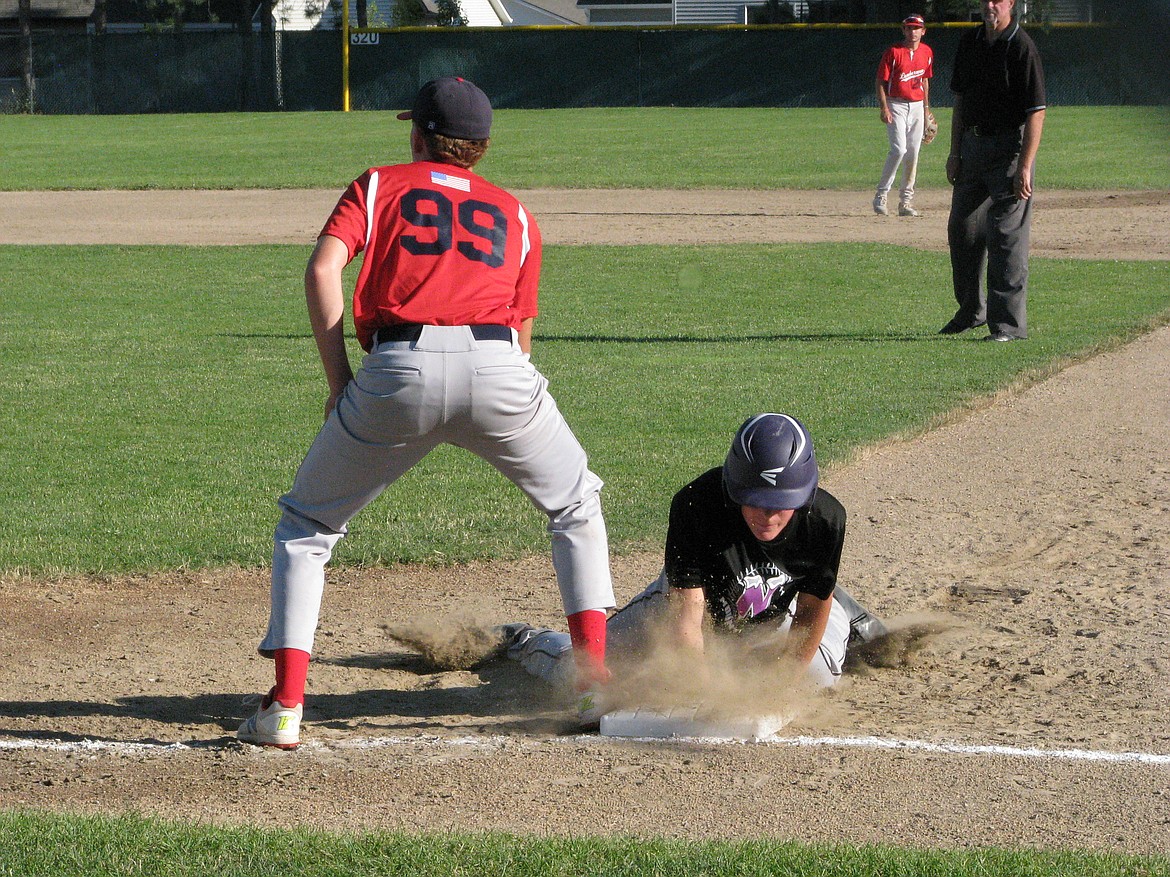 MARK NELKE/Press
Sam Pemberton of Northern Lakes dives back to first base on a pickoff attempt as Coeur d’Alene first baseman Liam Paddack awaits the throw.