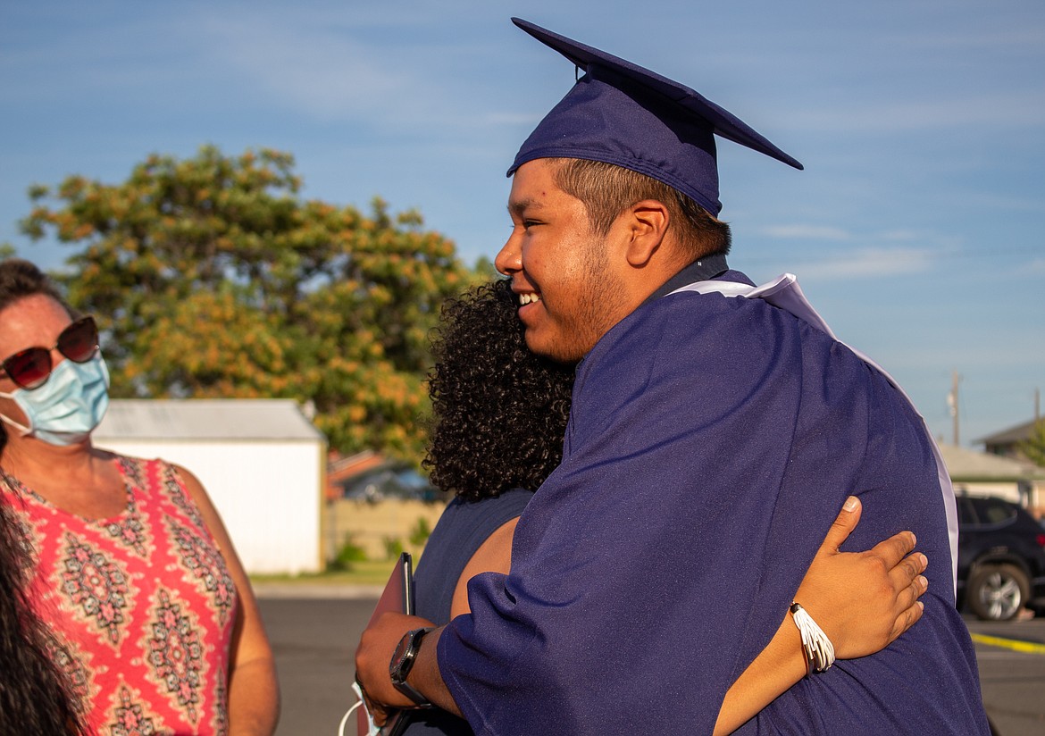 Casey McCarthy/The Sun Tribune
2020 Desert Oasis High School graduate Fernando Sayas can’t help but smile as he takes in a hug after crossing the stage at the school’s graduation celebration on Thursday, July 16.