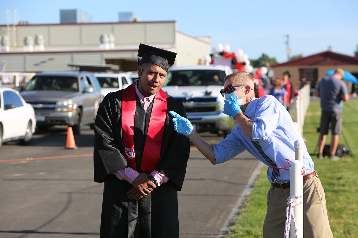 Emry Dinman/Columbia Basin Herald Hoping to keep the crush of students and cars moving and in sync, district staff helped point out where students needed to walk to receive their diploma.