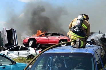 Evergreen Fire Rescue Captain James Boyce tends to a fire in several vehicles in the junkyard at Tri City Auto & Wrecking along U.S. Highway 2 East near Glacier Park International Airport on Wednesday. Evergreen, Columbia Falls and West Valley fire departments responded to the fire, as well as GPIA’s Aircraft Rescue and Firefighting vehicle. (Casey Kreider/Daily Inter Lake)