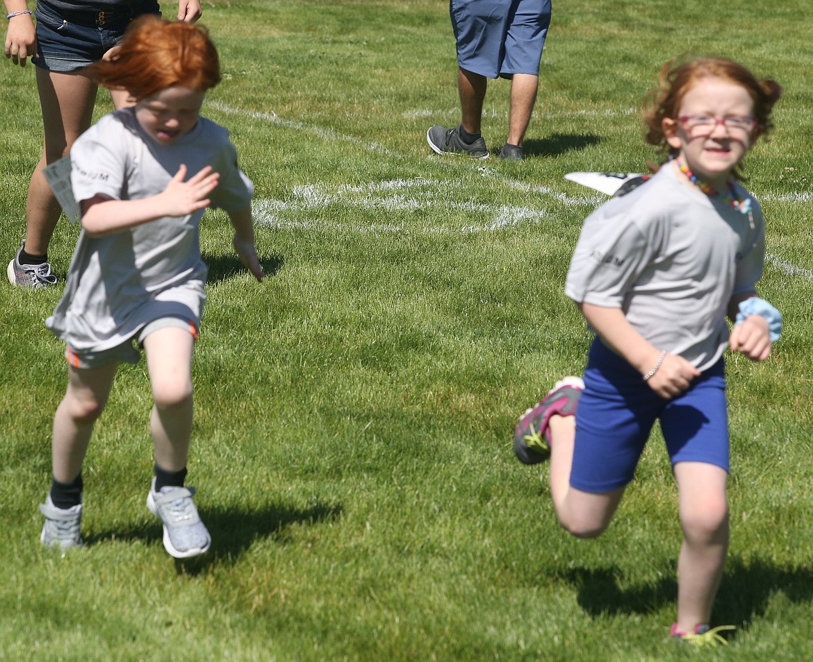 JASON ELLIOTT/Press 
 Xanadu Hotmer, left, tries to catch her sister Leia Hotmer during the Kids quarter mile race of the Race to Summer fun run on Saturday at Volunteer Park in Spirit Lake.