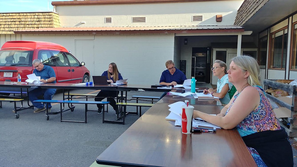 Plains School Board members listen to a presentation at last week’s meeting held outside due to social distancing concerns. (Chuck Bandel/Valley Press)