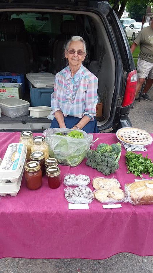 Anna Smith, Northwest Indian Bible School volunteer, displays some of the fresh goods for sale at the Alberton Farmer's Market. (Monte Turner/Mineral Independent)