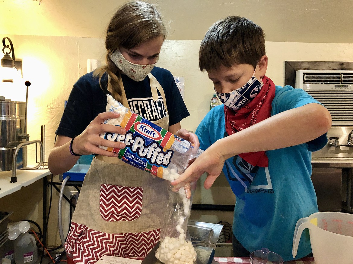 Kathryn Phillips, 15, and her brother Austin, 10, measure out eight ounces of marshmallows for rocky road fudge.