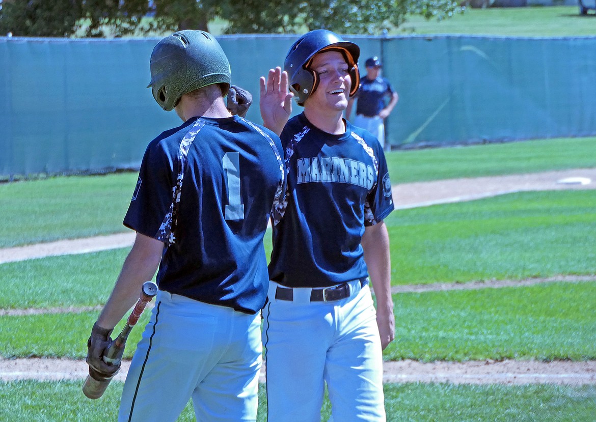 Mariners' Xavier Fisher celebrates with Keyan Dalby (1) after scoring a run in the final inning of a game against the Glacier Twins on Saturday, July 25. (Whitney England/Lake County Leader)