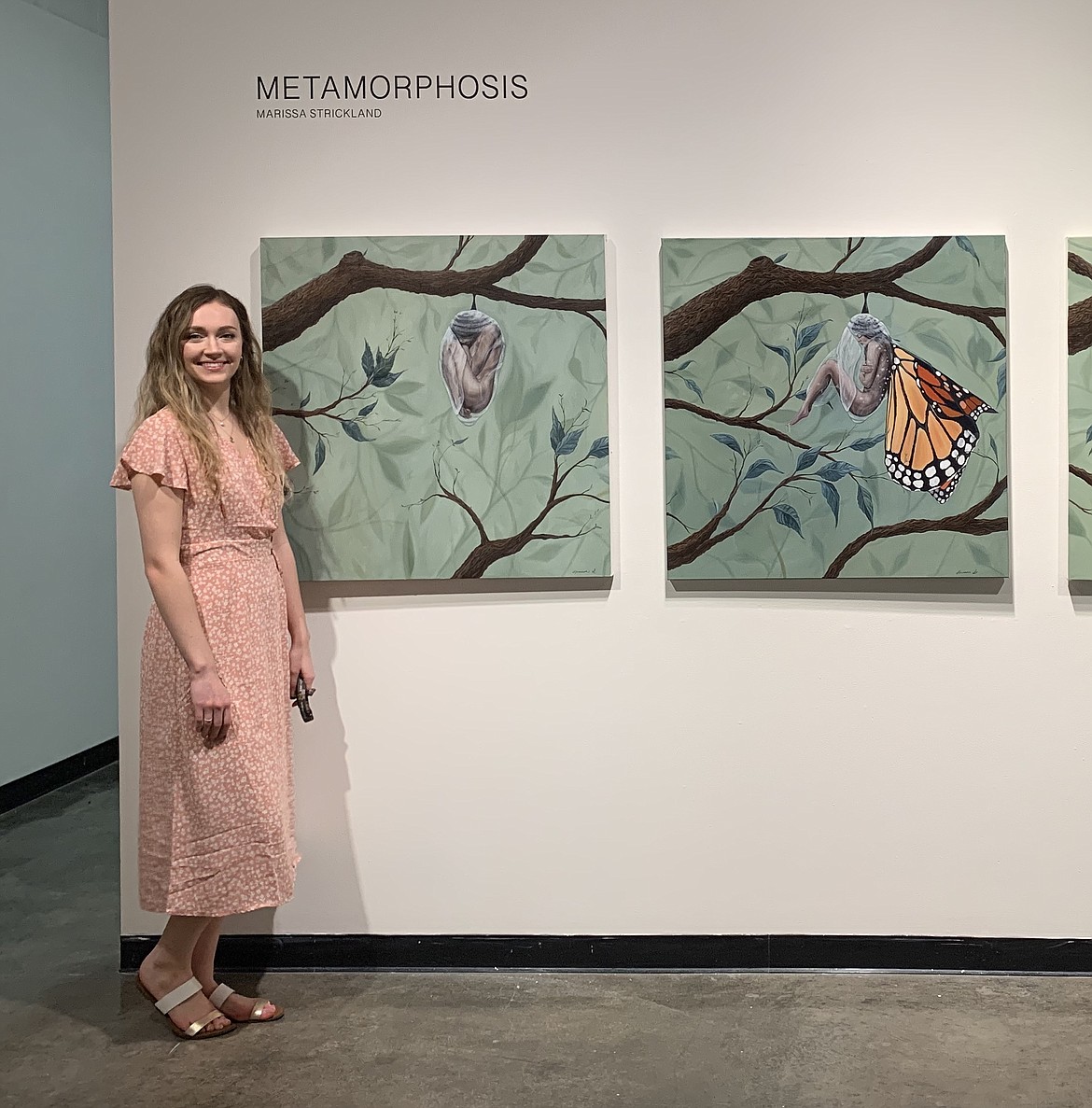 Marissa Strickland poses with her paintings during her show “Metamorphosis” at Gallery 231 on the campus of Central Washington University.