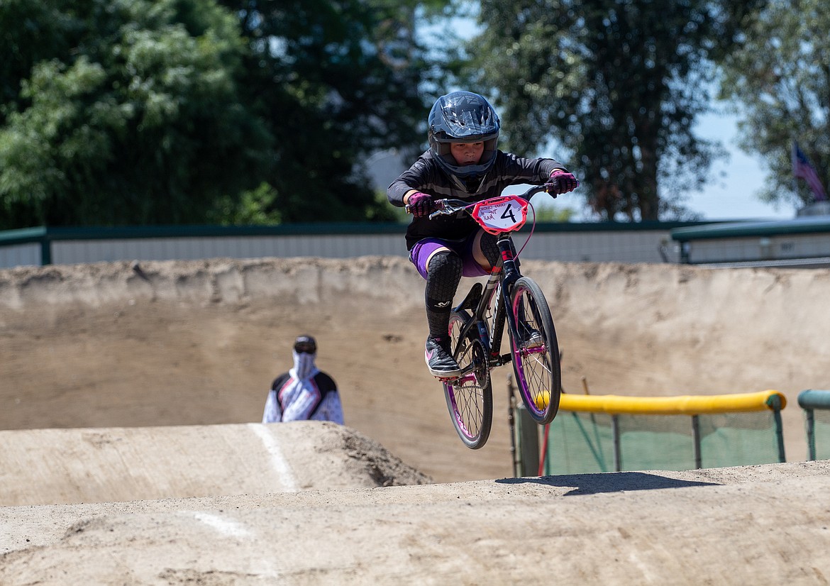The bike floats above the dirt as a young BMX rider makes their way around the track in Moses Lake as riders warmed up for the next wave of races at Moses Lake BMX’s single-point race event.