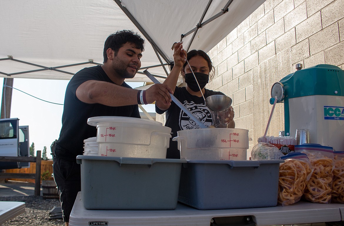 Eli Barajas, left, and Karla Rangel, pack up products for the day at La Popular’s booth at the Othello Farmers Market on Thursday.