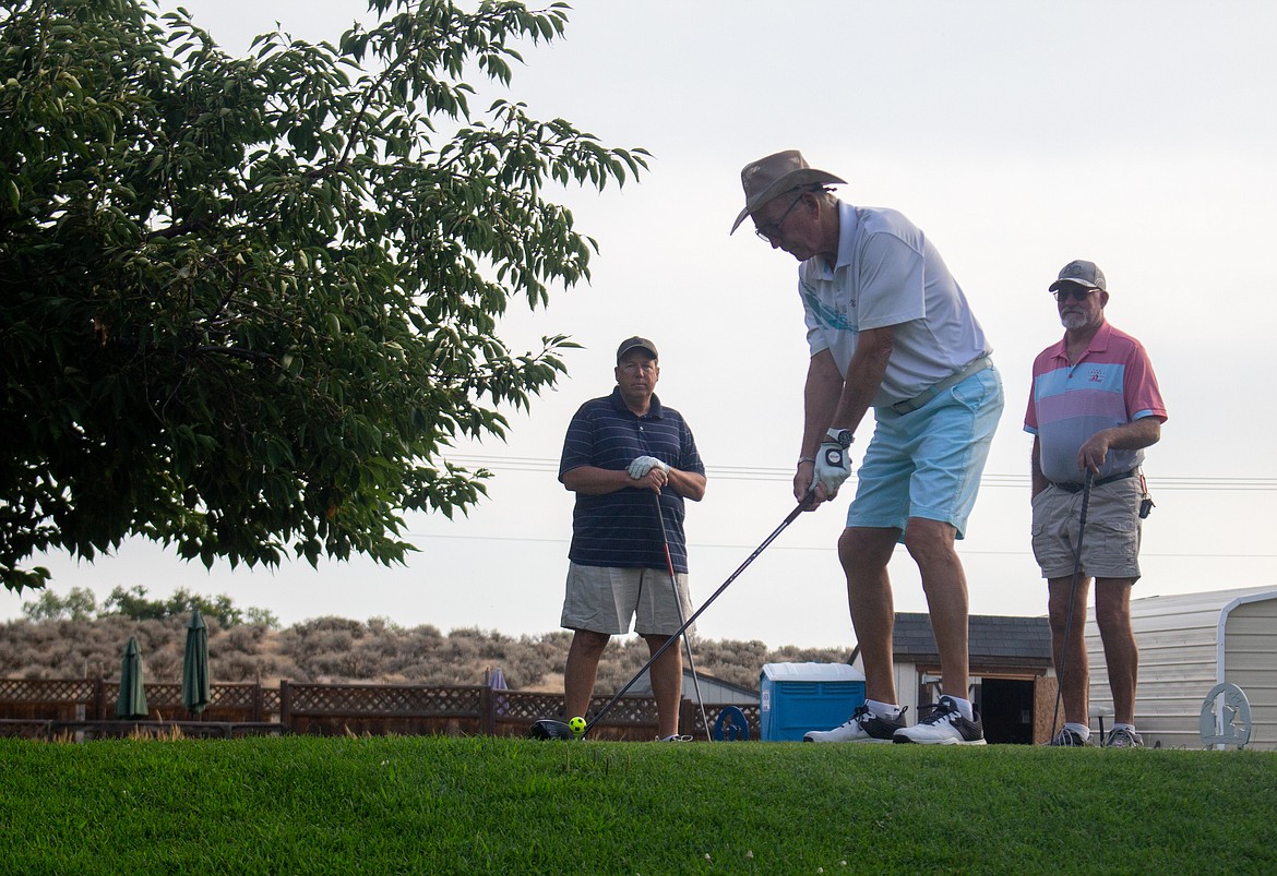 Chris Beaushaw, left, and Mark Olmsted, right, watch Mike Jones fire off his tee shot on the first hole at The Legacy Golf Course and Resort on Saturday morning for the course’s fundraising tournament.