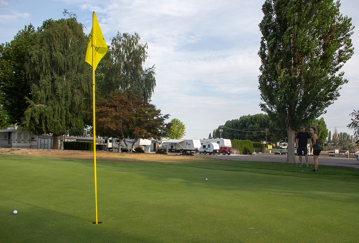 Casey McCarthy/The Sun Tribune
Legacy Golf Course General Manager Charlie Jenkins and fiancé Shannon Raynovich watch Raynovich’s shot roll towards the flag on the eighteenth green on Saturday morning.