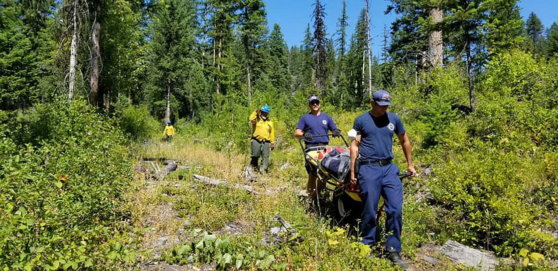 WHITEFISH FIRE Department first responders transport a woman who fell while climbing Sunday afternoon in the Point of Rocks area near Olney. The woman was taken to Kalispell Regional Medical Center for treatment. (Photo courtesy Whitefish Fire Department)
