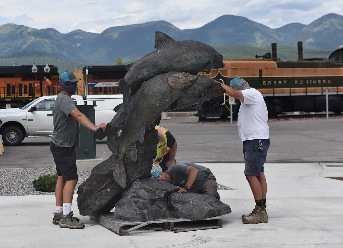 Workers look for a suitable place for installing the Whitefish Rising sculpture along the north end of Central Avenue across from Depot Park. The sculpture was removed from the park when the pond in the park was also removed. (Heidi Desch/Whitefish Pilot)