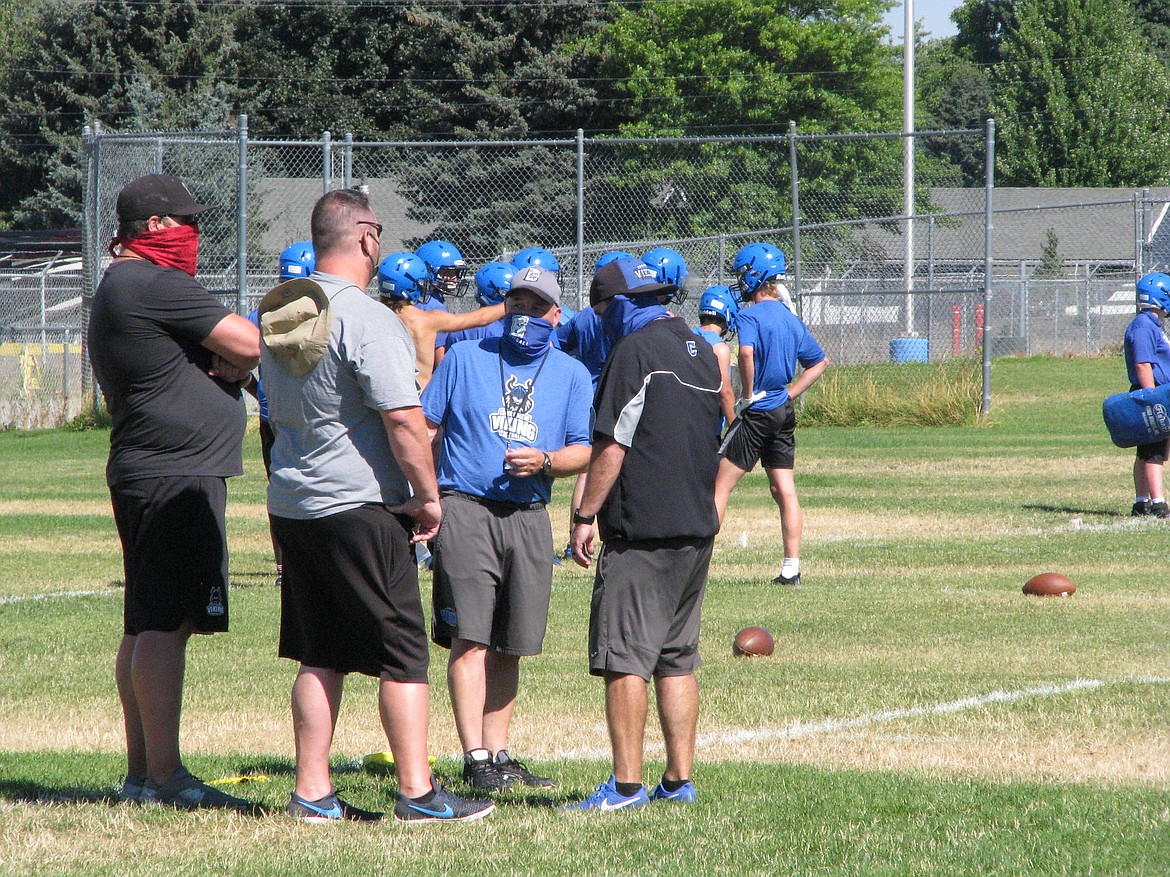 Coaches sport face coverings Monday during the first day of football practice at Coeur d’Alene High School. From left, Viking assistants Colin Donovan and Corey Brown, head coach Shawn Amos and assistant coach Dustin Shafer.