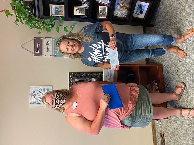Courtesy photo 
 Moses Lake Chamber of Commerce President Debbie Doran-Martinez, left, presents Sarah Bullinger of Movement Mortgage with her winnings from the Genie ball drop raffle.