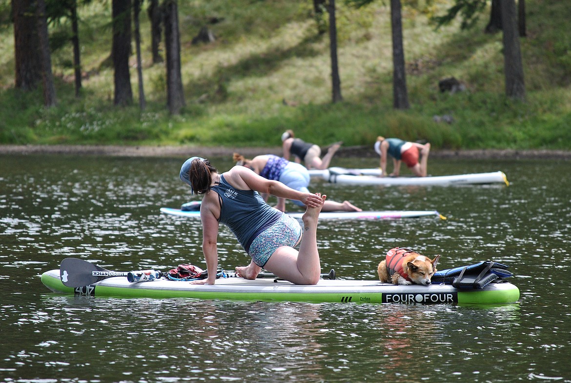 Mechelle Munroe, of Helena, leads a stand up paddle board yoga class on Saturday afternoon at Bouchard Lake near Superior. She is the owner of 406 Livin: SUP Yoga, a business that provides workshops, lessons, and gear around western Montana. This is the fourth year she has led “SUP CAMP” at this location. All together they had 14 participants float around the tranquil waters, which is about 10 less than last year. Munroe explained, “It’s a full gamut of experiences in terms of beginners in yoga, paddle boarding, or both. Either way everyone that comes out is just encouraged to relax and enjoy their weekend here at this beautiful place.” The event was held Aug. 8-9 with camping overnight at the lake. (Amy Quinlivan/Mineral Independent)