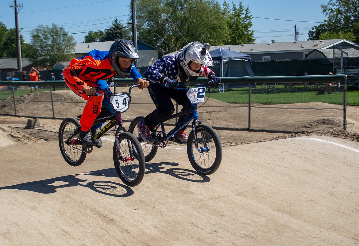 Casey McCarthy/Columbia Basin Herald 
 Hunter Schlager and Kaleb Gonzalez hang neck-and-neck as they head into the final turn of the BMX Track in Moses Lake at the single-point race event hosted by Moses Lake BMX on Saturday.