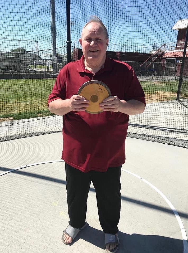 Courtesy Photo/ 
 Mike McCourtie holds his college discus inside his former throwing ring at Othello High School this summer.