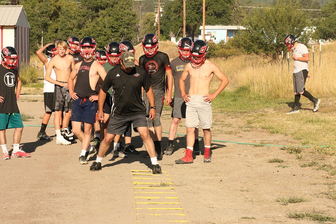 Hot Springs football coach Jim Lawson goes over a step drill with the team during last week’s practice. (Chuck Bandel/Valley Press)