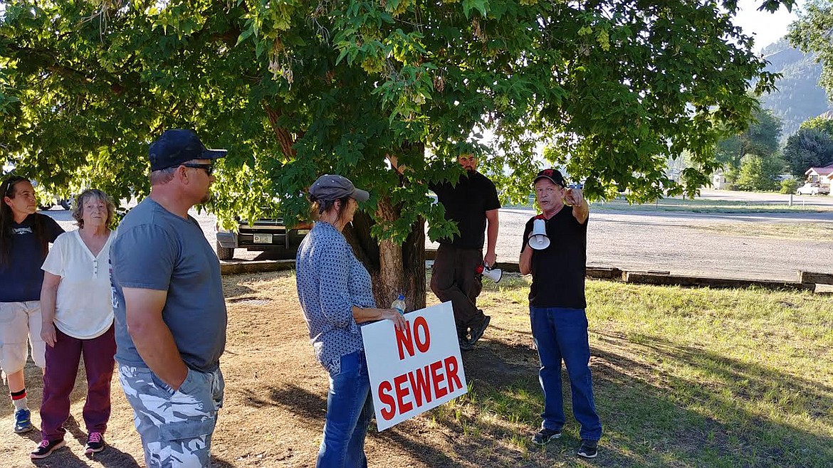 Paradise resident Tim French, far right, speaks to protesters in the park. (Chuck Bandel/Valley Press)