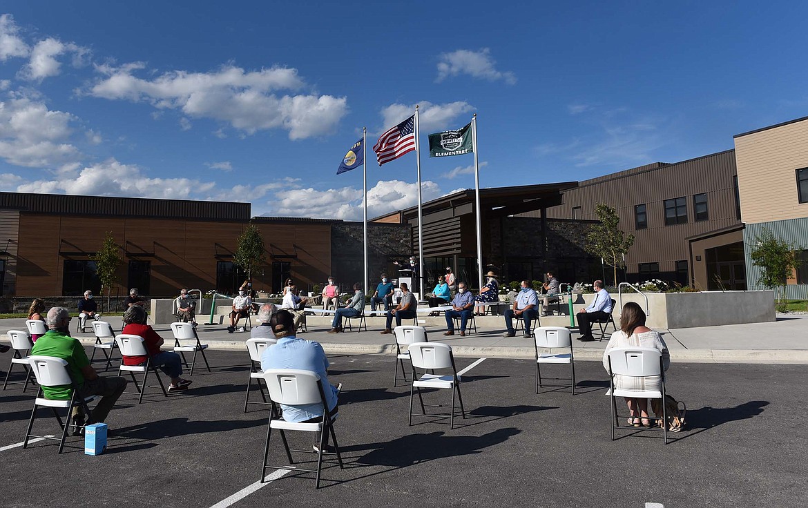 While sitting spaced apart to maintain social distancing, Whitefish School District officials, school board trustees and a few invited guests attended a ceremony last week in front of the new Muldown Elementary School to celebrate the completion of the new school building. (Heidi Desch/Whitefish Pilot)