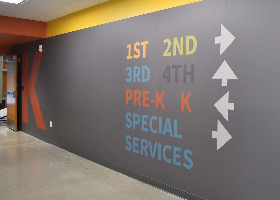 Directions on the wall inside the lobby of the new Muldown Elementary School building point the way to the various grades in the school. Each grade level has its own designated color and shape throughout the school. (Heidi Desch/Whitefish Pilot)