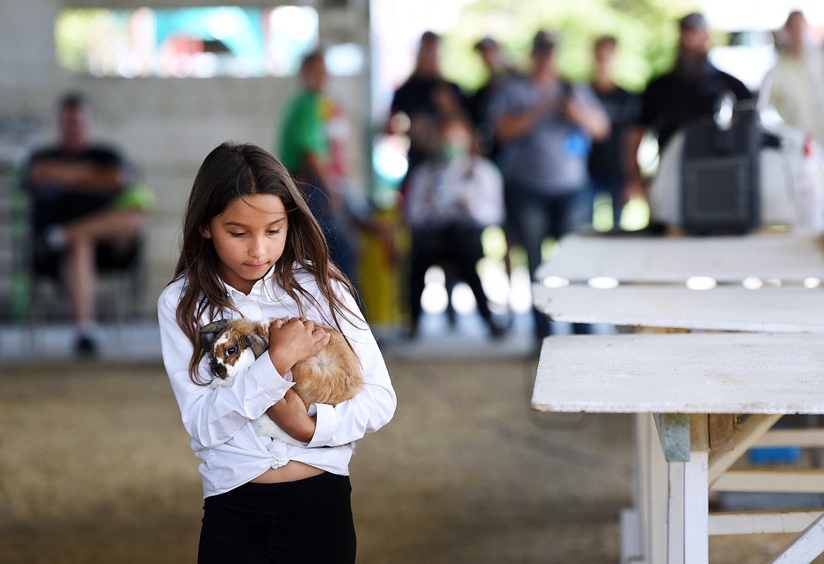 Baylee Ekern cradles her rabbit Mocha after it hopped away during judging at the junior novice 4-H/FFA Rabbit Showmanship at the Northwest Montana Fair & Rodeo on Wednesday. (Casey Kreider/Daily Inter Lake)