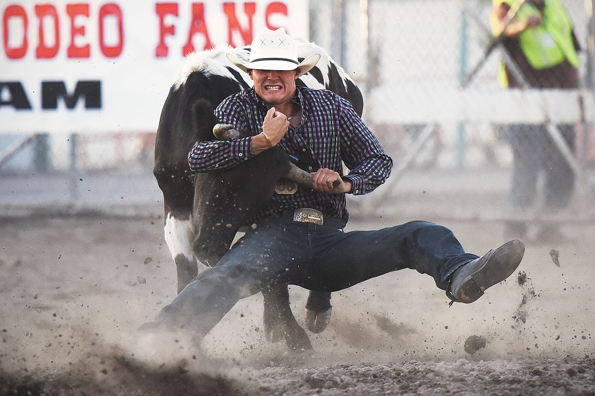 Ryan Shuckburgh from Innisfail, Alberta, Canada, brings his steer to the ground during steer wrestling at the rodeo on Thursday. (Casey Kreider/Daily Inter Lake)