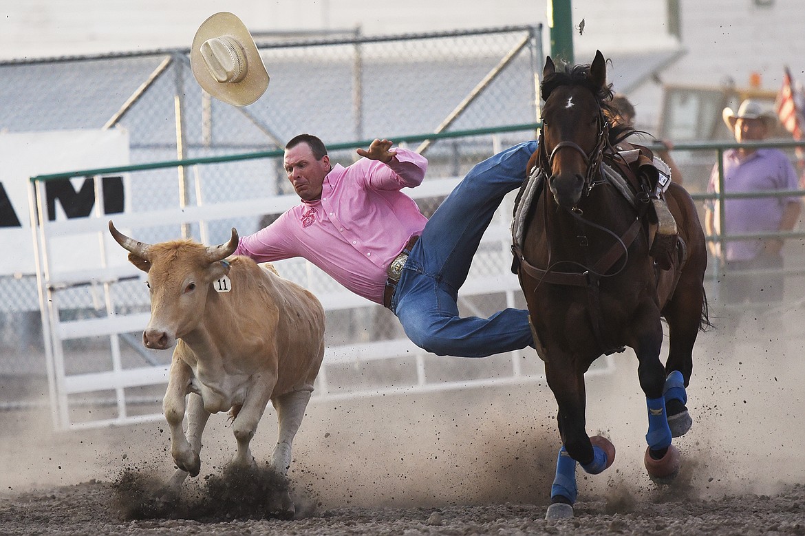 Ted Gollaher, from Cascade, tries to bring his steer to the ground during steer wrestling at the Northwest Montana Fair & Rodeo on Thursday, Aug. 20. (Casey Kreider/Daily Inter Lake)