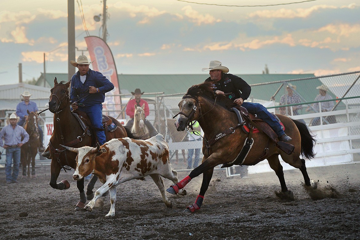 Nick Guy, right, from Sparta, Wisconsin, pursues his steer in steer wrestling at the Northwest Montana Fair & Rodeo on Friday, Aug. 21. (Casey Kreider/Daily Inter Lake)