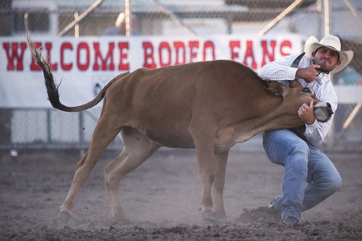 Justin Kimsey, from Kennewick, Washington, takes his steer to the ground in steer wrestling at the Northwest Montana Fair & Rodeo on Saturday, Aug. 22. (Casey Kreider/Daily Inter Lake)