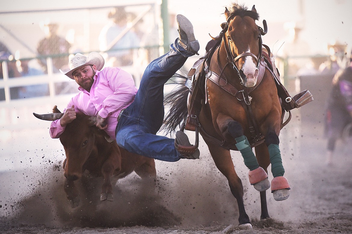 Chase Black, from Coalville, Utah, takes his steer to the ground during steer wrestling at the Northwest Montana Fair & Rodeo on Saturday, Aug. 22. (Casey Kreider/Daily Inter Lake)