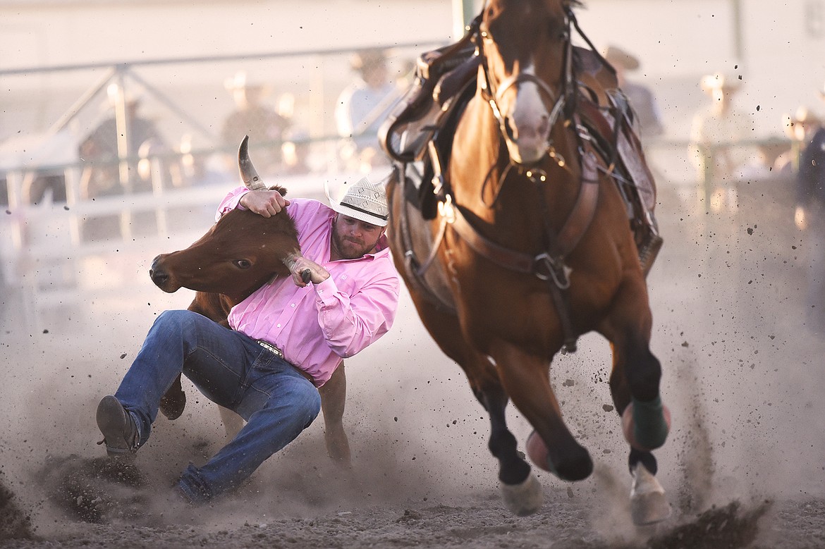 Chase Black, from Coalville, Utah, takes his steer to the ground during steer wrestling at the Northwest Montana Fair & Rodeo on Saturday, Aug. 22. (Casey Kreider/Daily Inter Lake)