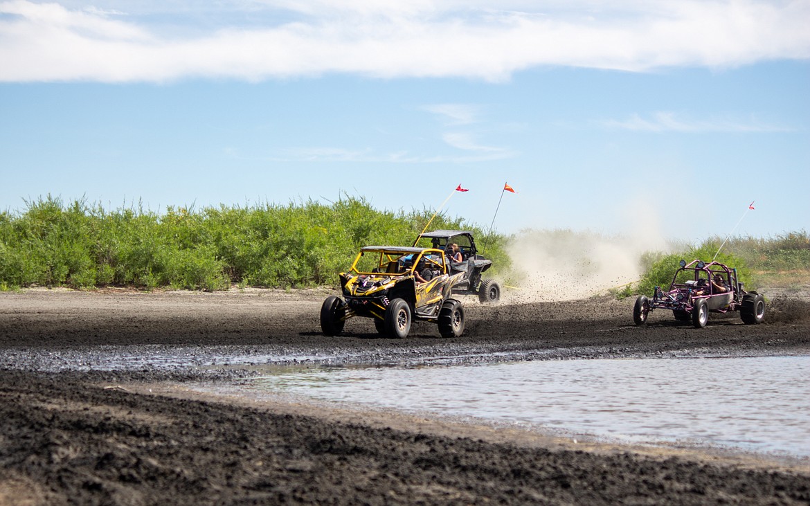 Casey McCarthy/Columbia Basin Herald 
 Vehicles come soaring across the mud out of a turn at the annual Off Road Race Around the Bowls event at the Moses Lake Sand Dunes on Saturday afternoon.