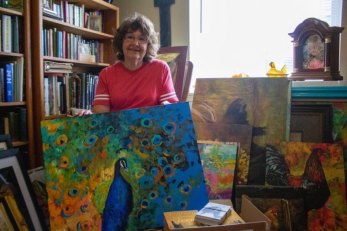 Casey McCarthy/Columbia Basin Herald
Local artist Jan Thacker holds up one of her numerous paintings in her home in Moses Lake on Tuesday, as she gets her work ready to head off to the Phillips Studio and Gallery in Kalispell, Montana.