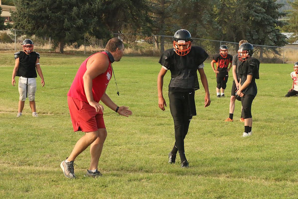 Plains football coach Eddie Fultz (in red) teaches blocking and tackling technique during a recent practice. (Chuck Bandel/Valley Press)