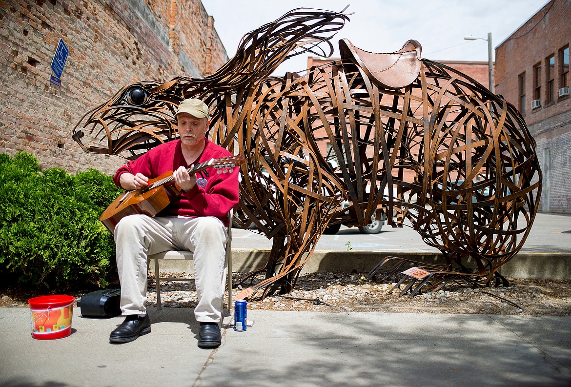 Ron Wetmur of Coeur d’Alene plays an acoustic guitar along to classic rock tunes on Sherman Avenue between Fourth and Fifth street during the 2016 Street Music Week. This year the event has been physically canceled because of the pandemic, but efforts to support Second Harvest Food Bank and local musicians are taking place online.