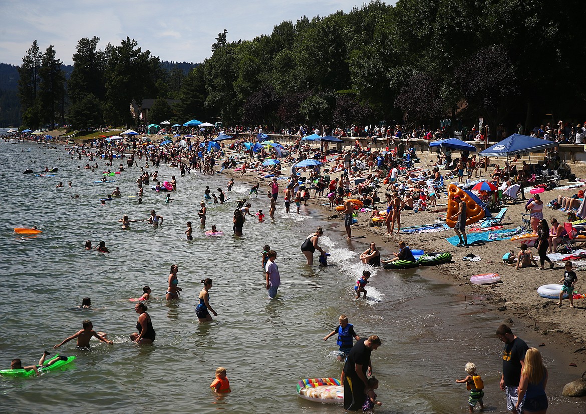 LOREN BENOIT/BJNI File
Locals and tourists relax on the beach and wade in the water at City Beach in downtown Coeur d’Alene during Fourth of July.