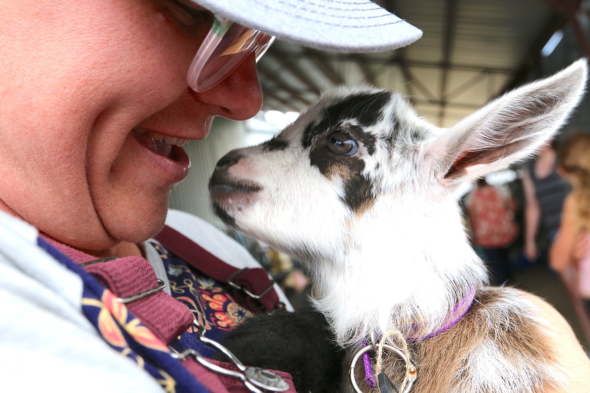 Bonner County Fair Manager Darcey Smith enjoys one of the perks of the jobs — cuddling a two-week-old baby goat at the fair’s animal petting zoo — at a past fair.